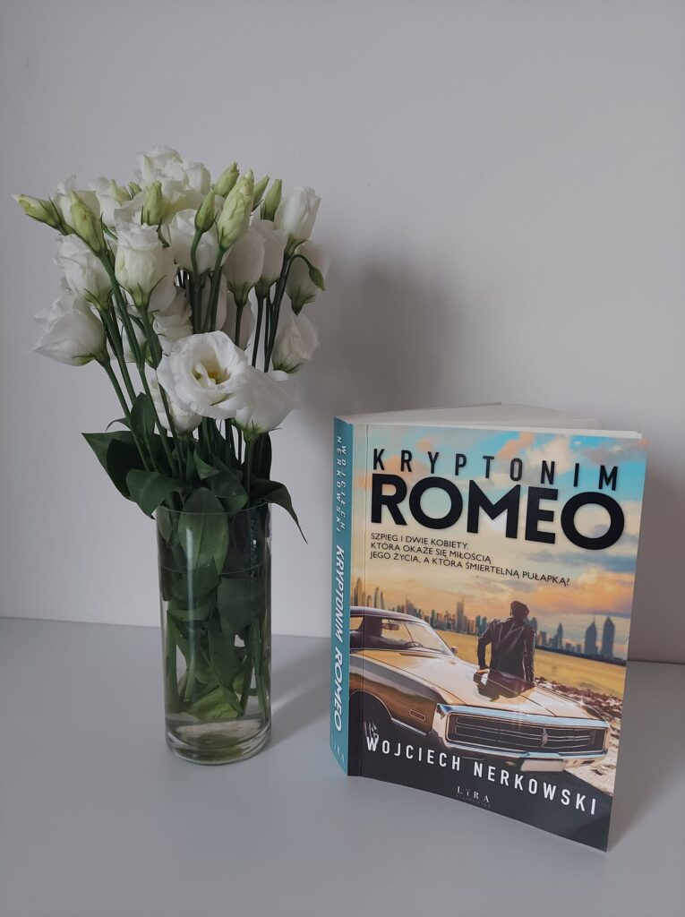 wazon z białymi różami i książka Kryptonim ROMEO