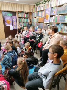 grupa zasłuchanych dzieci między książkami