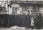21.01.1934 rok przed sklepem w Gębicach. Kawalerka: trzeci od lewej to Wacław Grześkowiak czterech mężczyzn i dziecko przed budynkiem składu towarów