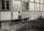 Krzyżanki, dworek, przed 1945 rokiem chłopiec siedzi porzed starym budyniem