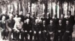 leśnicy elegancko ubrani pozują do zdjęcia, w tle drzewa